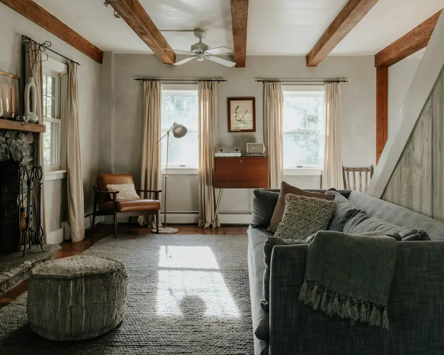Warm living room with a lit fireplace and exposed beams